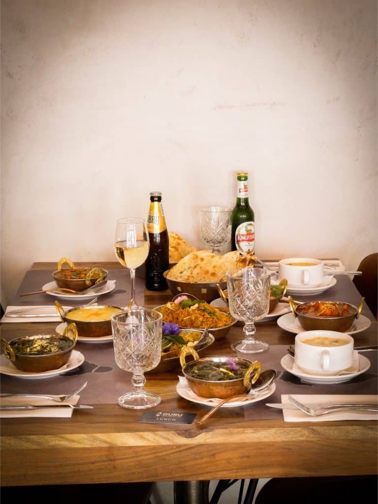 Authentic Indian feast presented for Polish guests, featuring aromatic curries served in traditional bowls, freshly baked naan, fragrant rice, and elegant tableware—inviting Polish diners to experience rich Indian flavors in a warm, welcoming setting